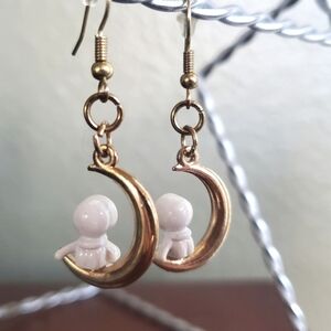 Space astronomy astronaut figure sitting on gold crescent moon dangle earrings